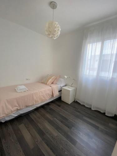 - une chambre blanche avec un lit et une fenêtre dans l'établissement AMPLIO Y LUMINOSO APART Cerca del CENTRO HISTORICO LM, à Valence