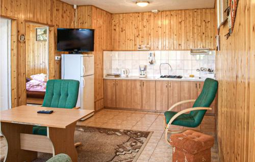 a kitchen with a table and chairs and a refrigerator at Cozy Apartment In Kopalino With Kitchenette in Kopalino