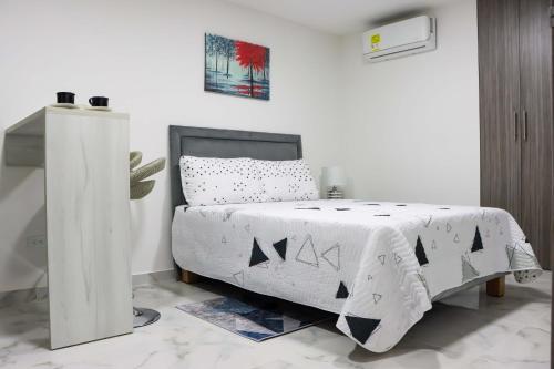 a bedroom with a bed with a black and white comforter at Apartaestudio moderno en Cali 1 in Cali