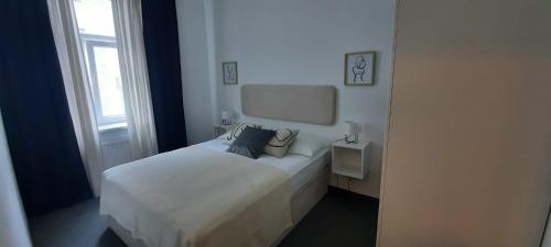a white bed in a room with a window at Apartments DOLAC Zagreb in Zagreb