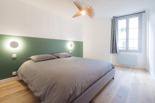 1 dormitorio con 1 cama grande y pared verde en A modern flat in the center of Fontainebleau, en Fontainebleau