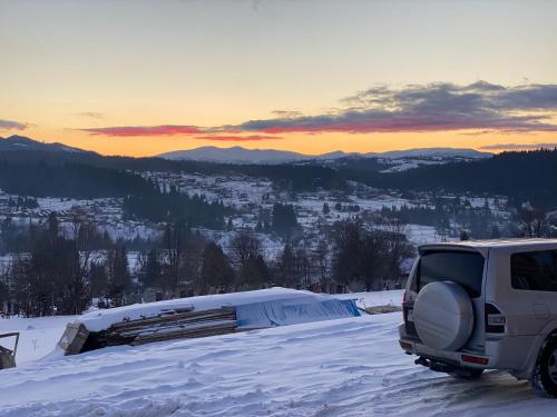 a suv parked on top of a snow covered mountain at Байка Карпат in Vorokhta