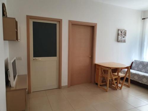 um quarto com uma mesa e uma porta e uma mesa e cadeiras em Apartment Emma em Velipojë