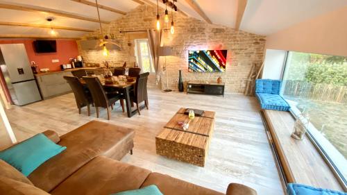 a living room with a couch and a table at Le Grenier - Gîte de Charme La Rochelle in Saint-Médard-dʼAunis