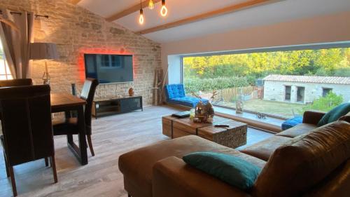 a living room with a couch and a table at Le Grenier - Gîte de Charme La Rochelle in Saint-Médard-dʼAunis