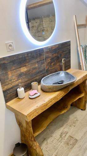 a bathroom with a sink on a wooden table with a mirror at Le Grenier - Gîte de Charme La Rochelle in Saint-Médard-dʼAunis