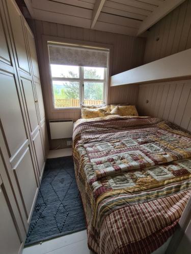 um pequeno quarto com uma cama e uma janela em Cozy Cottage in Icelandic nature with Hot tub em Akranes