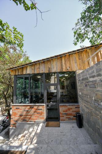 a house with glass doors and a brick wall at Madin Eco Hotel in Debed