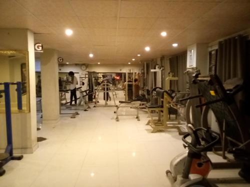 a gym with lots of treadmills and machines at Furnished One Bed Room Apartment Ground Floor With Kitchen in Karachi