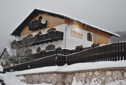 a building with a clock on the side of it at Wellness Pension Fulda Černý Důl in Cerny Dul