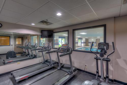 a row of treadmills in a gym with mirrors at Country Inn & Suites by Radisson, Crystal Lake, IL in Crystal Lake