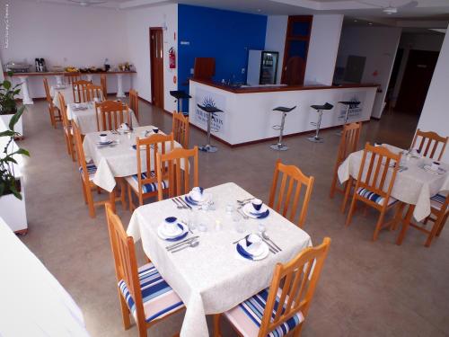 a dining room with tables and chairs with dishes on them at The Hyperion Boutique Hotel in Florianópolis
