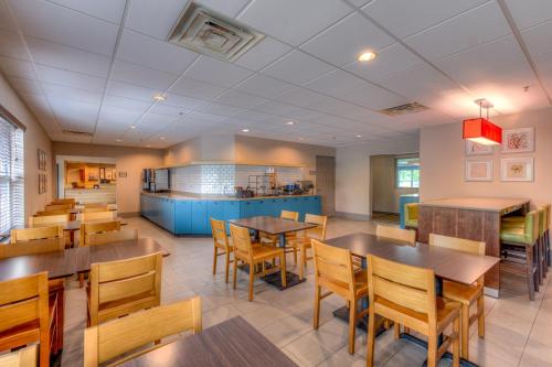 a dining room with wooden tables and chairs at Country Inn & Suites by Radisson, Crystal Lake, IL in Crystal Lake