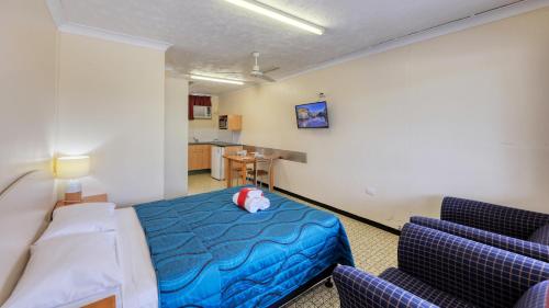 Wallace Motel And Caravan Park في ماريبورو: غرفه عليها سرير وحشره