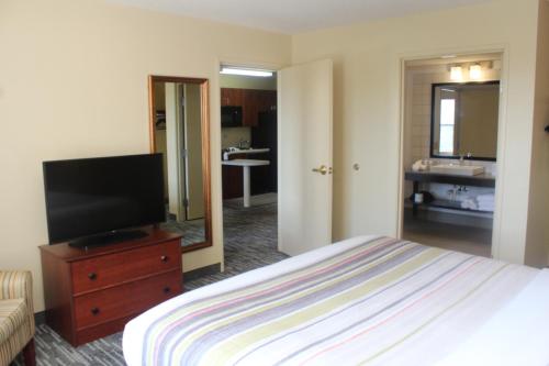 a bedroom with a bed and a flat screen tv at Country Inn & Suites by Radisson, Crystal Lake, IL in Crystal Lake