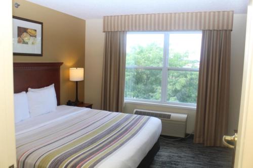 a hotel room with a bed and a window at Country Inn & Suites by Radisson, Crystal Lake, IL in Crystal Lake