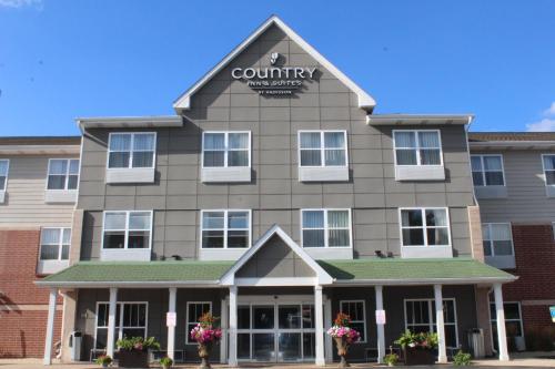 a front view of a building with a community sign on it at Country Inn & Suites by Radisson, Crystal Lake, IL in Crystal Lake