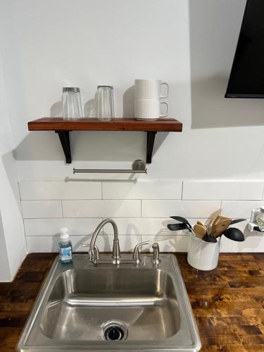 a kitchen sink with a wooden shelf above it at Tiny Home in El Paso
