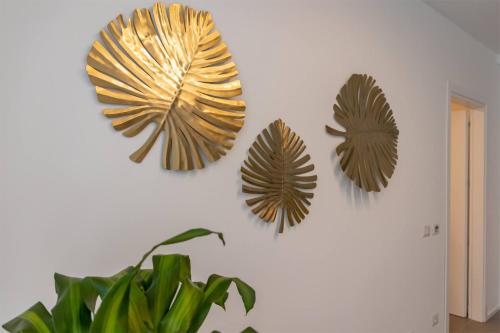 three fake leaves are hanging on a wall at Car.Ma - comfy rooms in Porto SantʼElpidio
