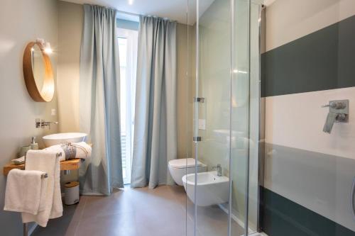 a bathroom with a toilet and a glass shower at Car.Ma - comfy rooms in Porto SantʼElpidio