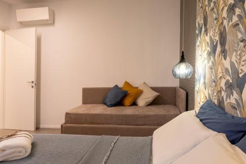 a bedroom with a couch with pillows on it at Car.Ma - comfy rooms in Porto SantʼElpidio
