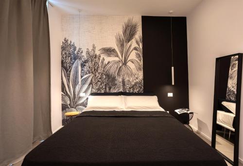a bedroom with a large black bed with a wall mural at Car.Ma - comfy rooms in Porto SantʼElpidio