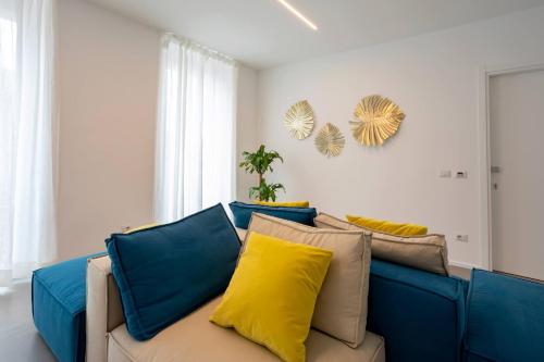 a blue couch with yellow pillows in a living room at Car.Ma - comfy rooms in Porto SantʼElpidio