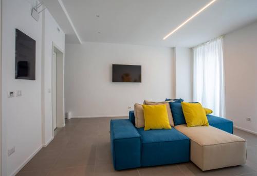 a blue couch with yellow pillows in a living room at Car.Ma - comfy rooms in Porto SantʼElpidio
