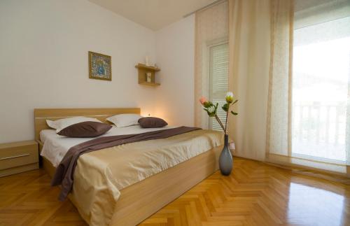 una camera con letto e vaso con fiori di Villa Katarina - private Pool 80m from beach a Marina