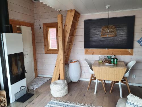 una habitación con mesa y sillas en una casa pequeña en Stunning log cabin 45m2 on the shore of Kallavesi. en Kuopio