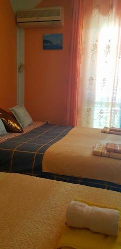 two beds in a room with a window at Guest House Cinderella in Herceg-Novi