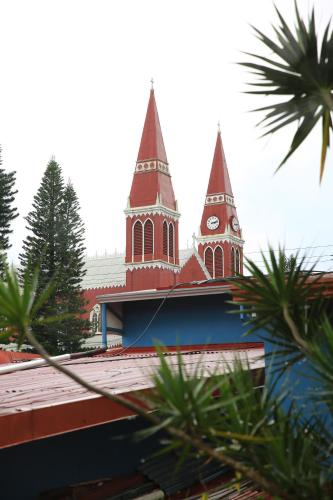 a church with two towers with a clock on it at Mangifera Hostel in Grecia