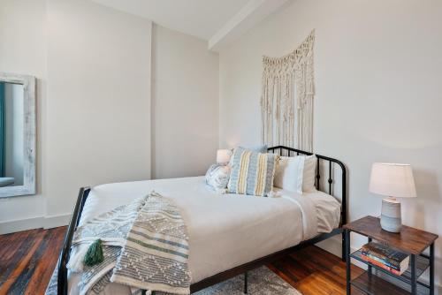 a bedroom with a bed and a table with a lamp at The Roxanne 1 - Chic One Bedroom Townhome in OTR in Cincinnati