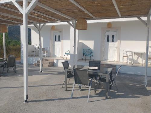 eine Terrasse mit einem Tisch und Stühlen unter einem Pavillon in der Unterkunft Mini Villas Avra in Keratókambos