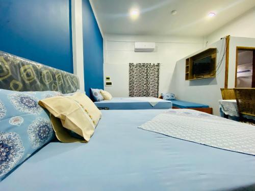 a bedroom with two beds with blue walls at SV Apart Hotel in Encarnación