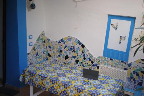 a bedroom with a bed with a mosaic head board at Villetta partenopea a pochi passi dal mare in Meta