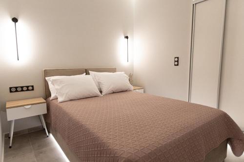 a small bedroom with a bed and a night stand at BillMar Luxury Apartment in the center of Gythio in Gythio