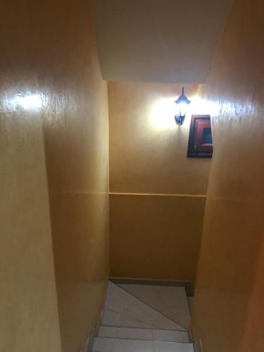a bathroom with a light on the wall and a hallway at Family house with a breathtaking Terrace view in Agadir