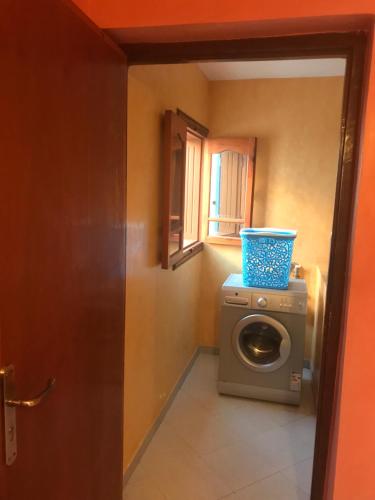 a washing machine with a blue bucket on top of it at Family house with a breathtaking Terrace view in Agadir