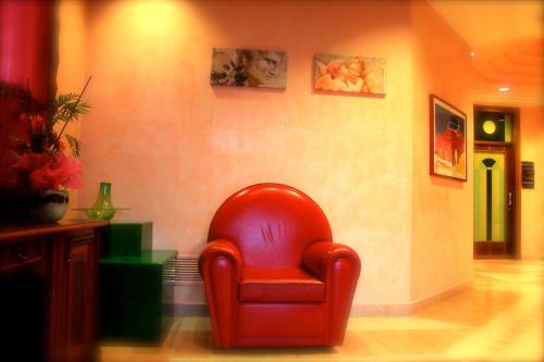 a red chair sitting in a living room at Park Hotel Italia in Tezze sul Brenta