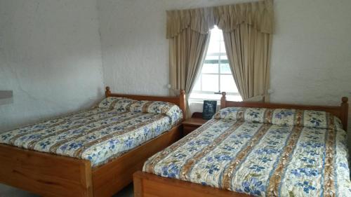 2 nebeneinander sitzende Betten in einem Schlafzimmer in der Unterkunft Las Palmas Hotel in Corozal