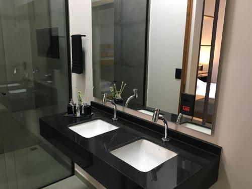 a bathroom with two sinks and a large mirror at Cantinho Estrelado - Casa automatizada com ALEXA in Brotas