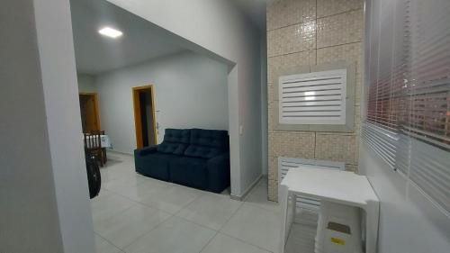 ein Wohnzimmer mit einem blauen Sofa in einem Zimmer in der Unterkunft Residencial Baldissera e Zeni in Machadinho