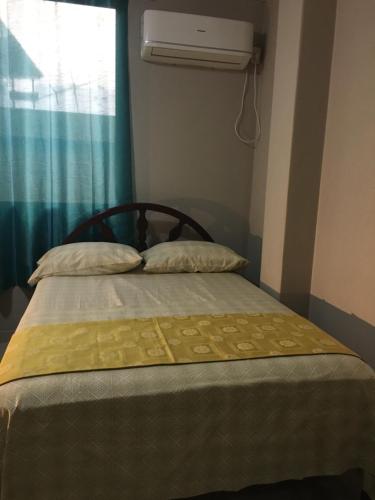 a bed with two pillows on it in a bedroom at Hotel Premier Inn in Manta
