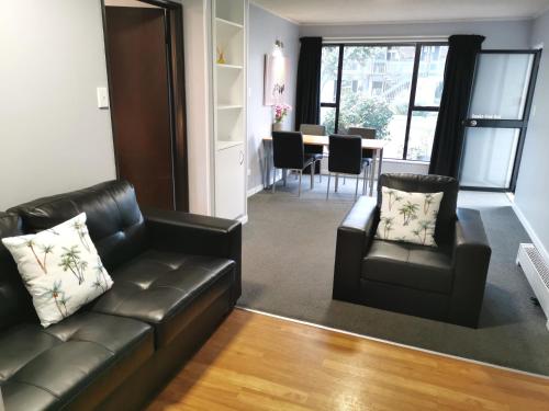 a living room with a couch and chairs and a table at Hacienda Motor Lodge in Palmerston North