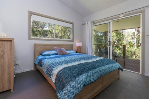 1 dormitorio con cama y ventana grande en Happy Daze, en Smiths Lake