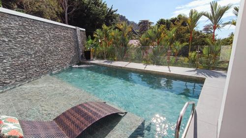 une piscine dans un jardin clôturé dans l'établissement SUNSET OCEAN VIEW CONDO, à Jacó