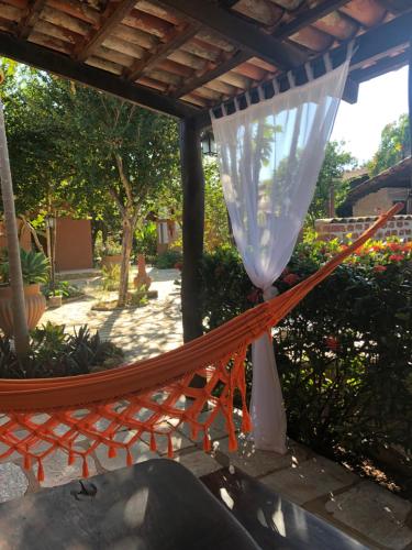 a hammock with a white curtain on a patio at Pousada Casa Grande in Pirenópolis