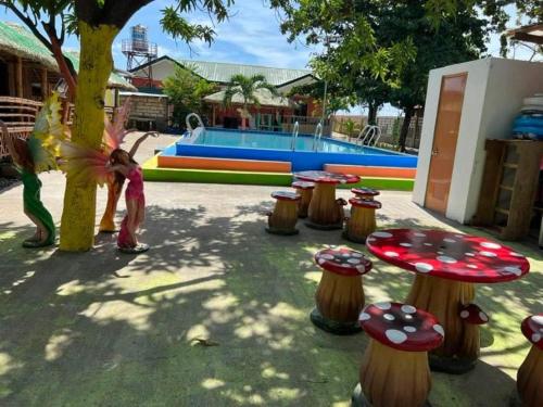 a little girl standing next to a playground with tables and stools at Scott's Seaview Resort in Danao City