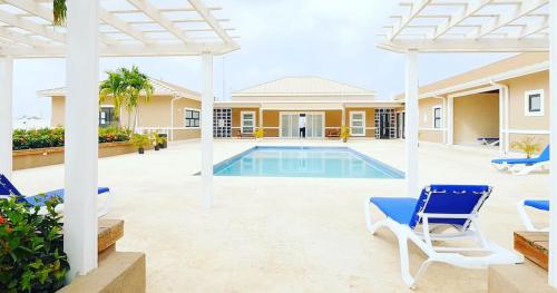 Villa con piscina y sillas azules en Natalia’s Sweet Oasis, en Lucea